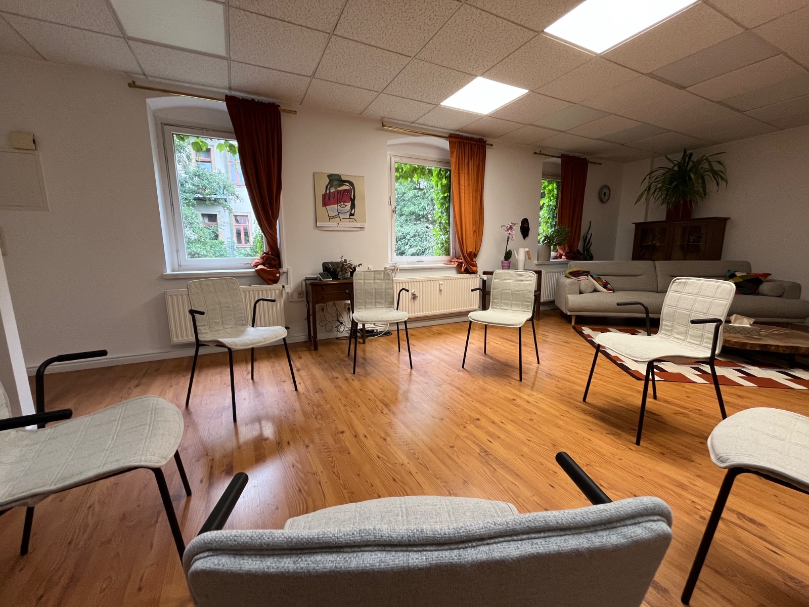 Praxisraum in der Hechtstraße 23 mit Stuhlkreis, Sofa und Blick ins Grüne