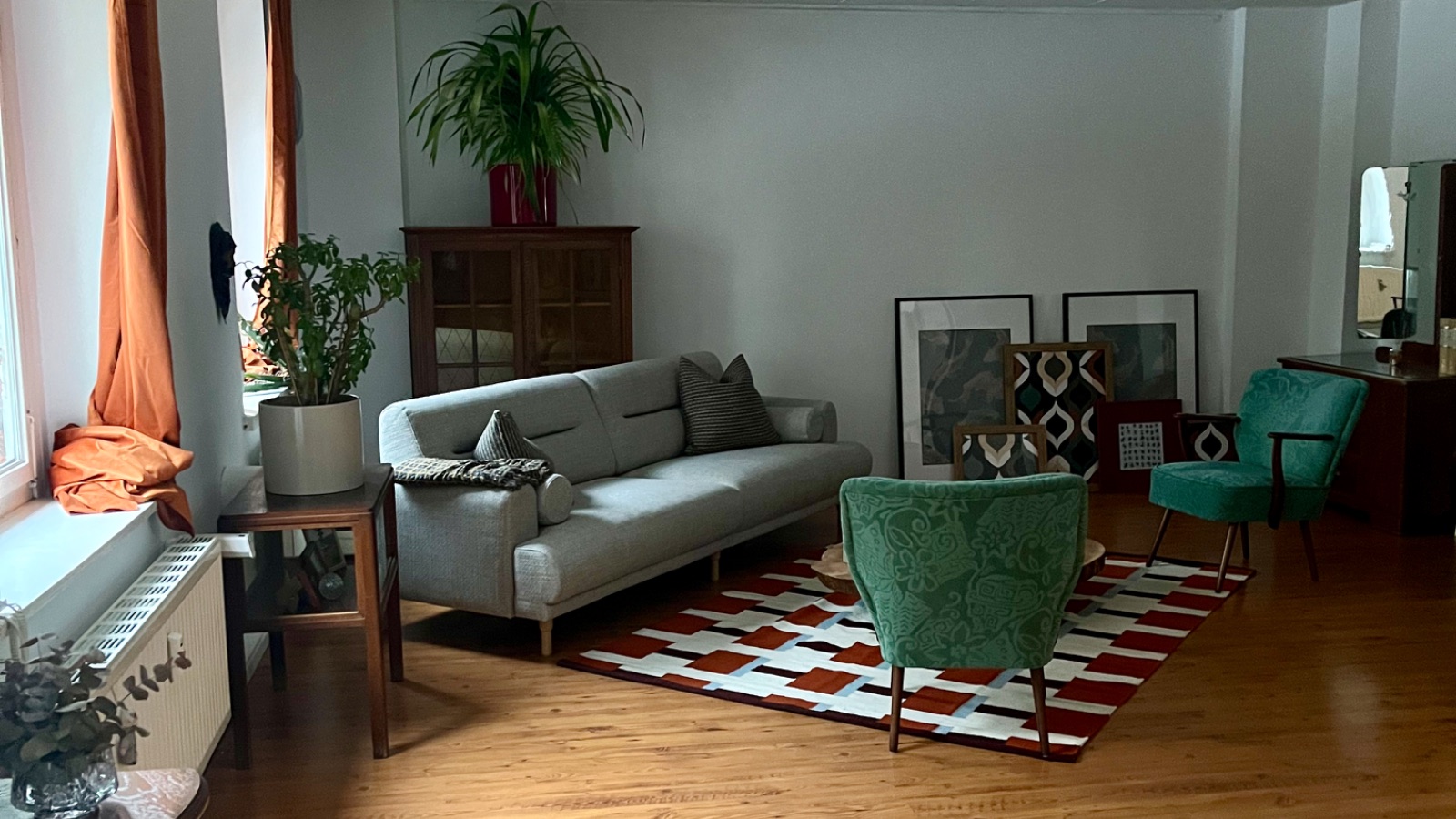 Sitzecke in der Praxis im Dresdner Hechtviertel mit grauem Sofa, zwei grünen Sesseln und gemustertem Teppich